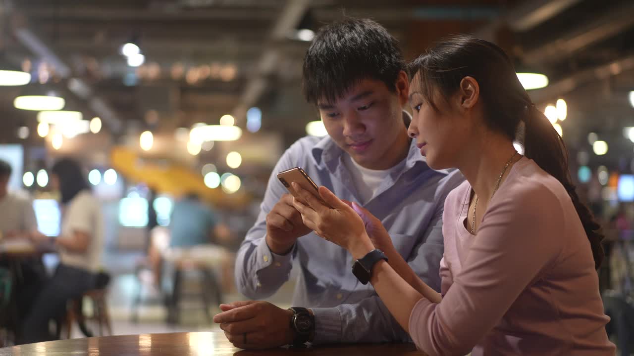 亚洲夫妇使用手机和共享屏幕视频素材