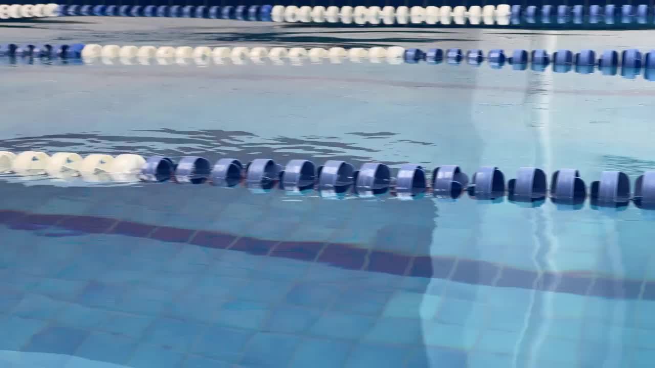 一个武装的女游泳运动员游泳蝴蝶的肖像视频下载
