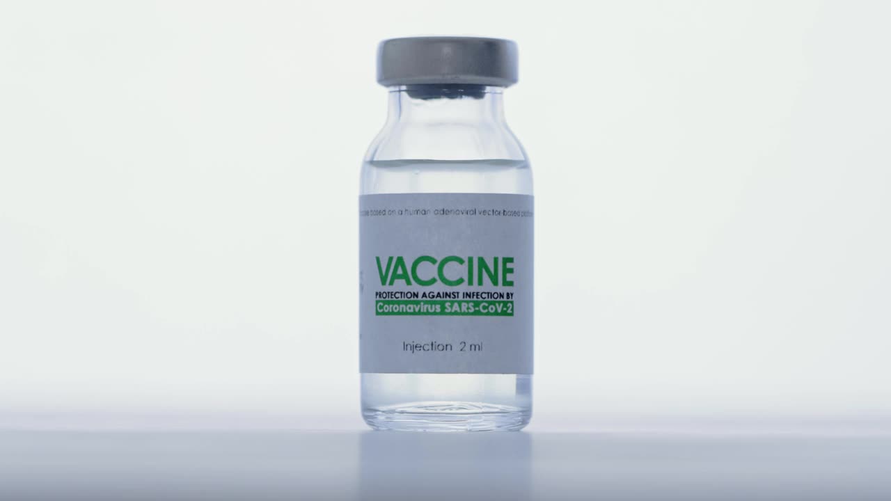 研究实验室，戴医用手套的医生拿着小瓶注射疫苗进行COVID-19冠状病毒治疗。接种疫苗的概念,大流行。宏。烧瓶以白光为背景视频素材
