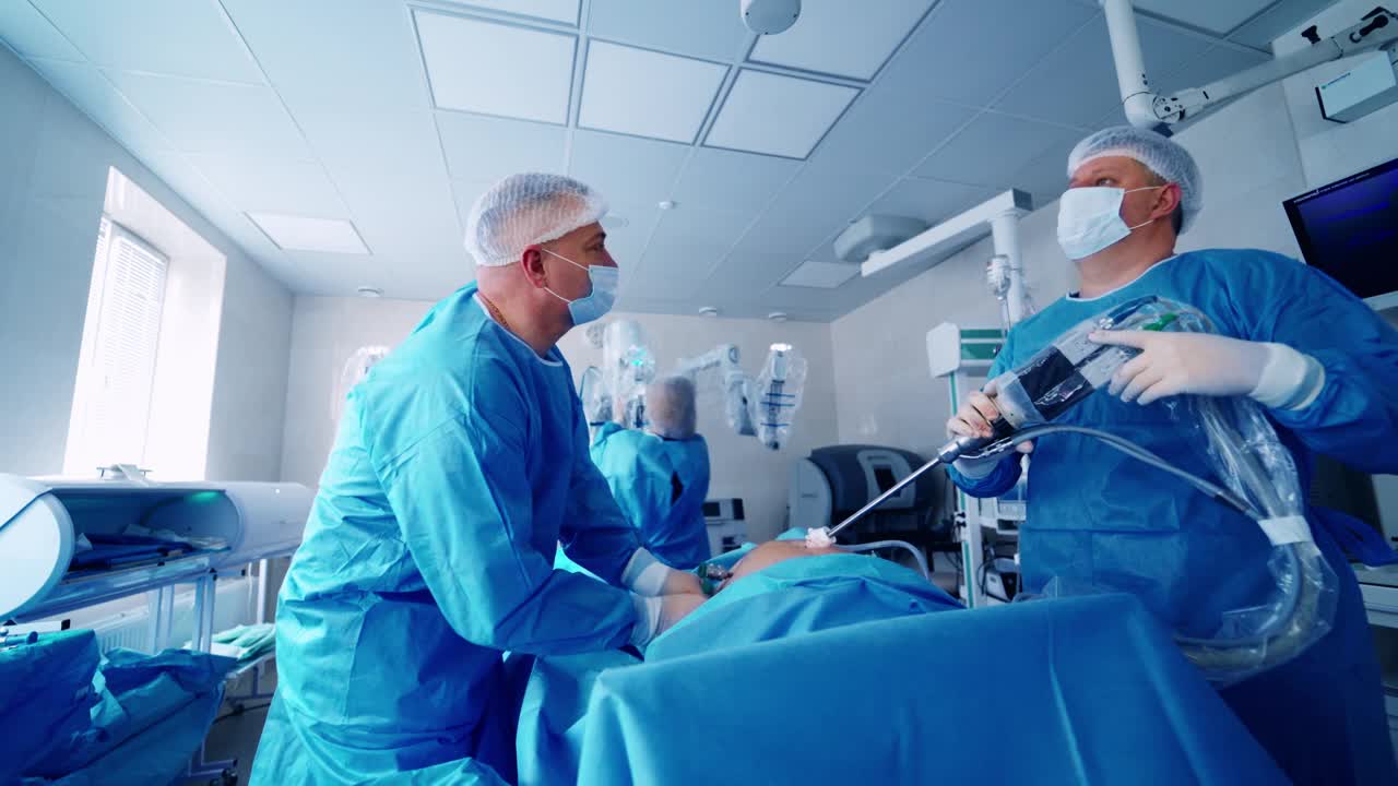 医生在医院的手术室里使用机器人。机械臂是一种现代医疗设备，在现代手术室中进行手术。视频素材