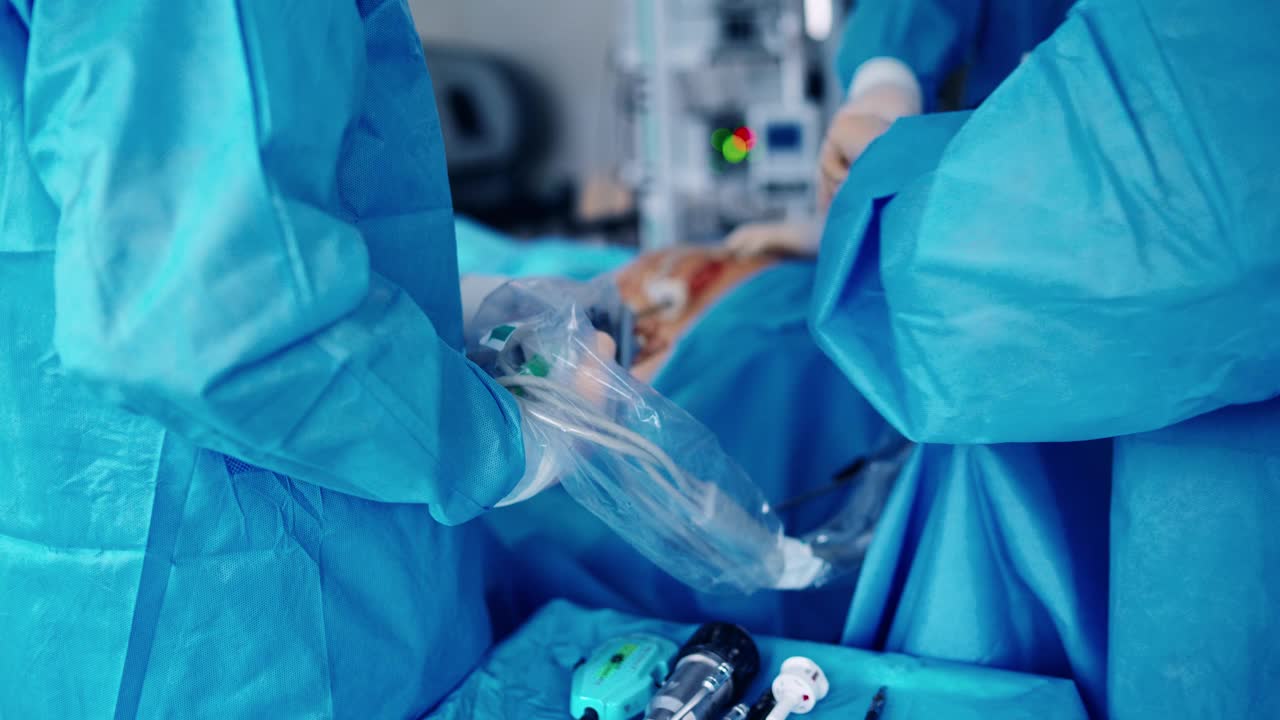 手术过程与机器人设备。一组外科医生穿着防护服在医院里做手术。医生使用高科技设备。特写镜头。视频素材