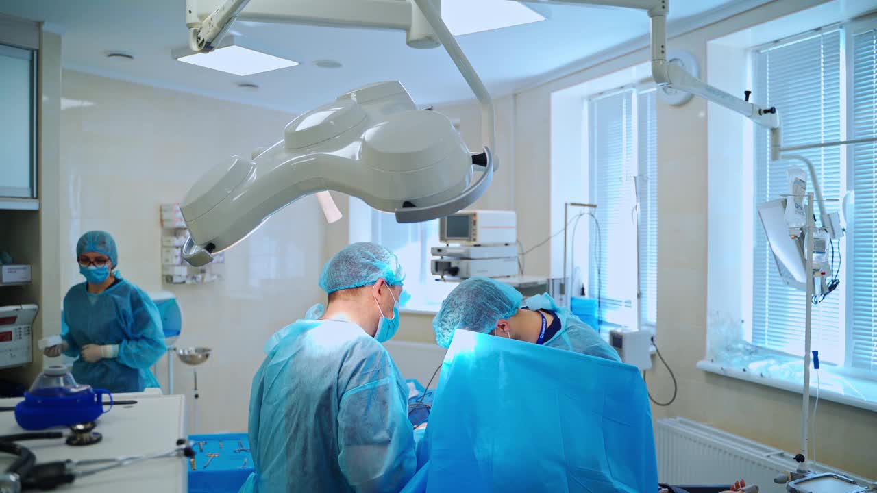 手术过程的手术室。一组外科专家在现代化的手术室里进行手术。外科处置视频素材