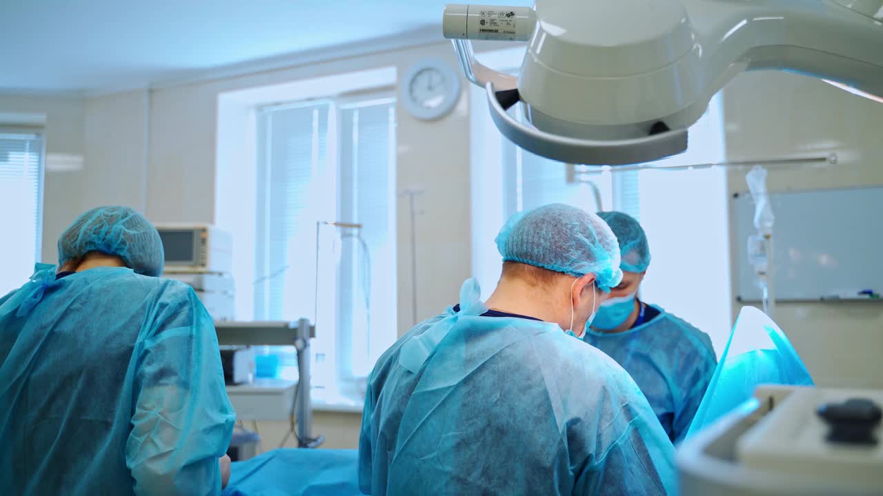 手术室里的外科医生和助手。在现代化的医院里，有一支专业的医生队伍进行手术。视频素材