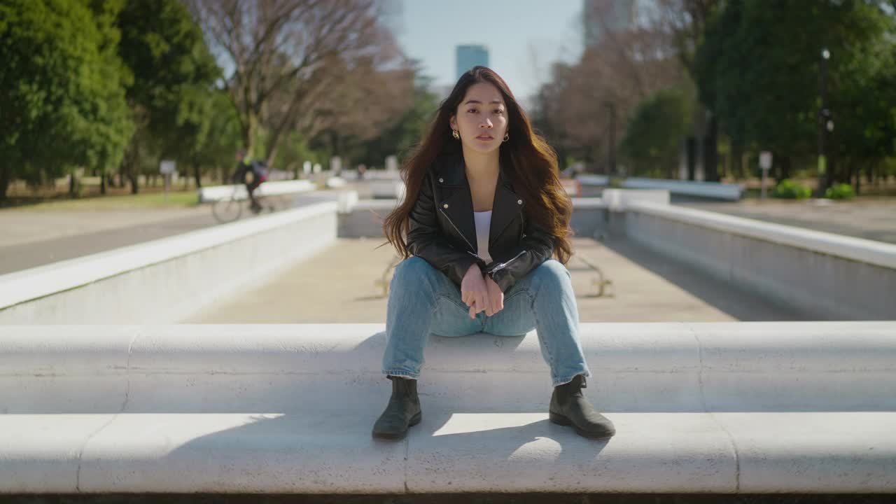 24帧/秒360度旋转的年轻女子坐在公园里。相机越来越接近模型了视频素材