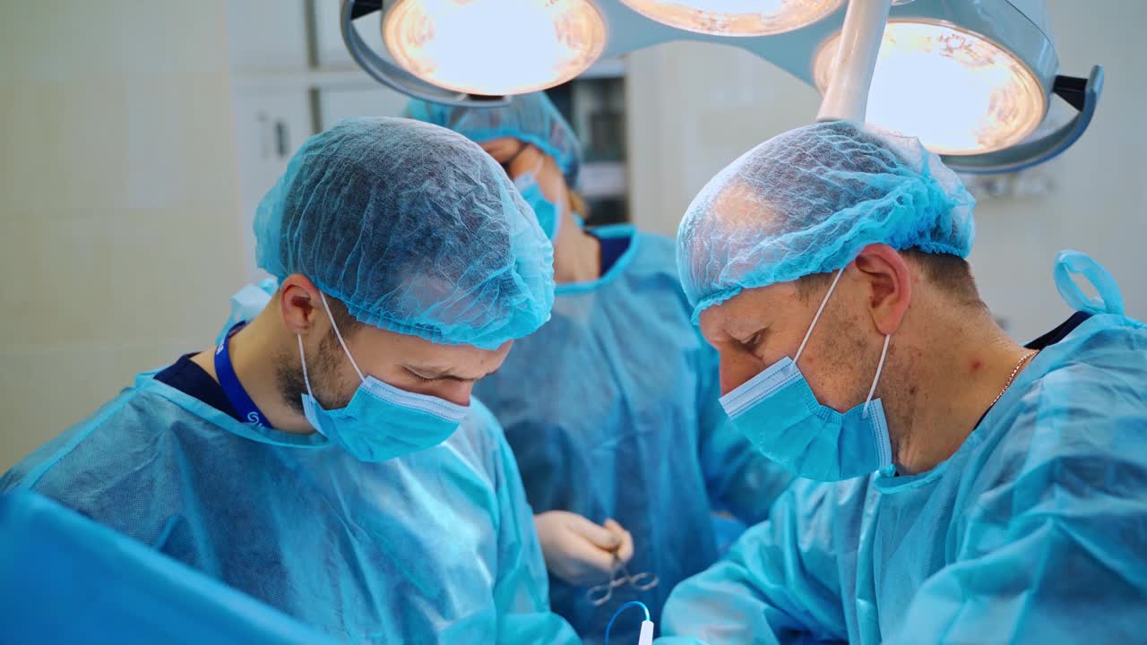 临床外科医生的团队合作。经验丰富的医生在现代手术室里用电子医疗工具进行手术。视频素材