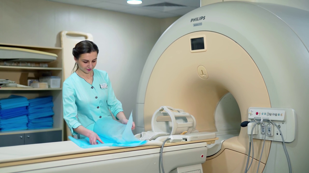 现代磁共振仪器在临床上的应用。实验室工作人员在扫描程序前准备好核磁共振机。视频下载