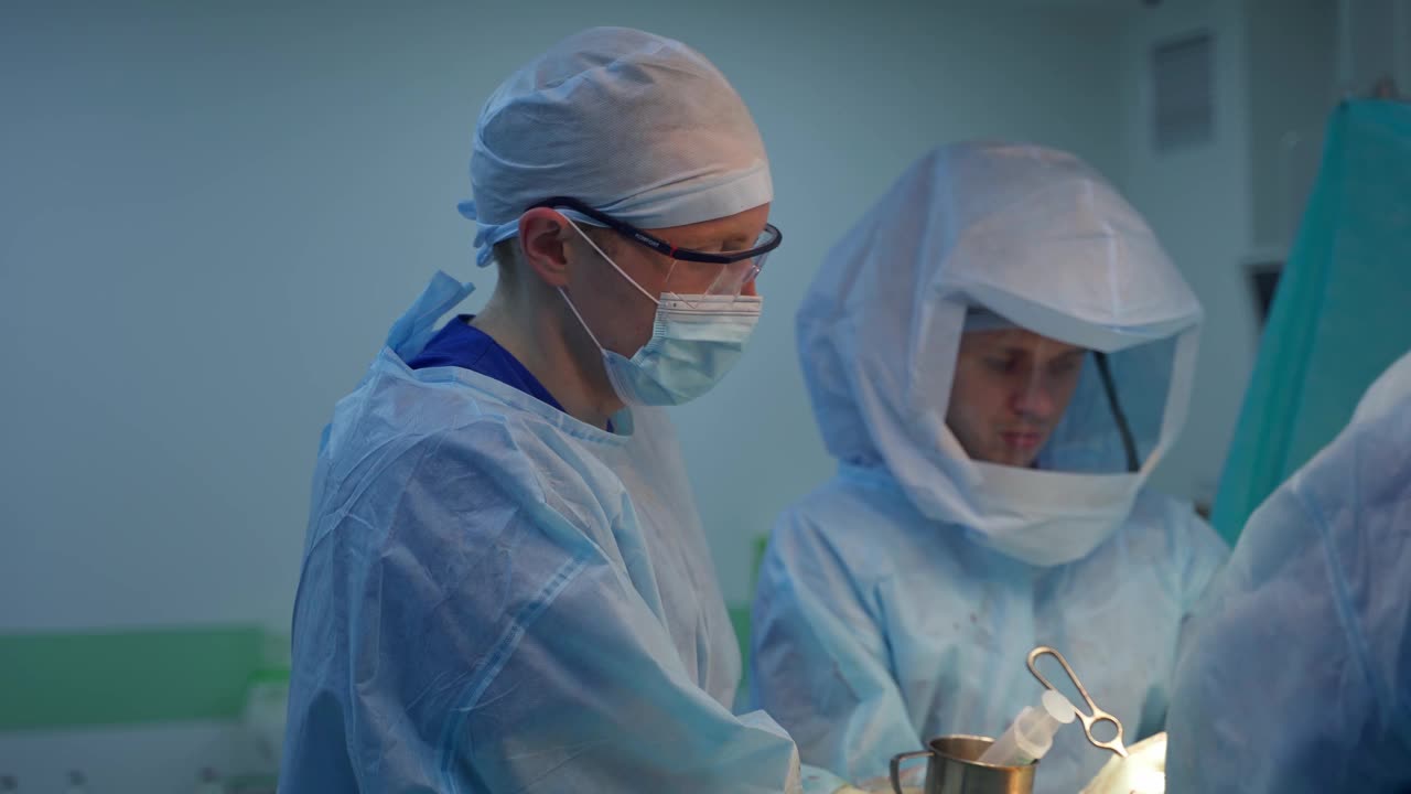 外科手术。医生们穿着防护服在手术室里工作。医学专家在诊所挽救病人的生命。视频素材