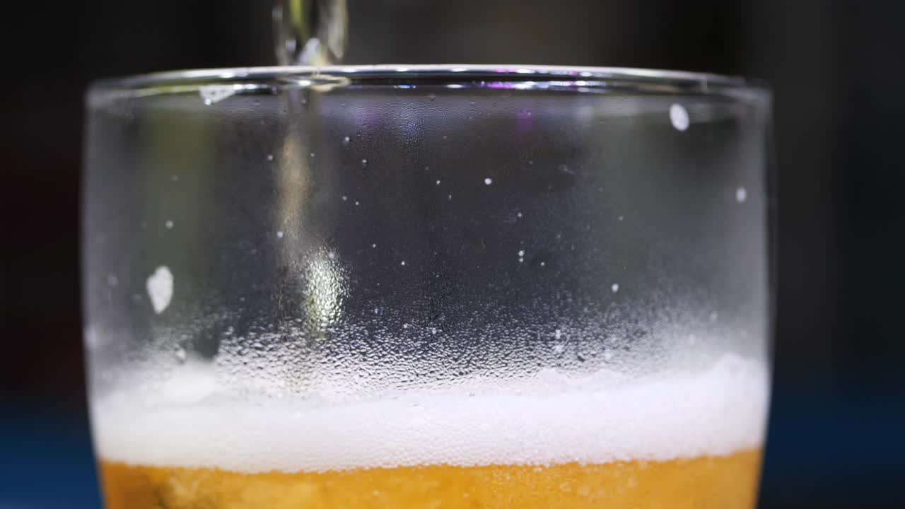 慢动作将啤酒倒进酒杯视频素材