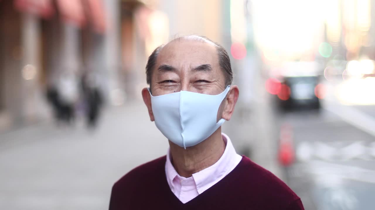 一位戴着面具微笑的日本老人。视频素材