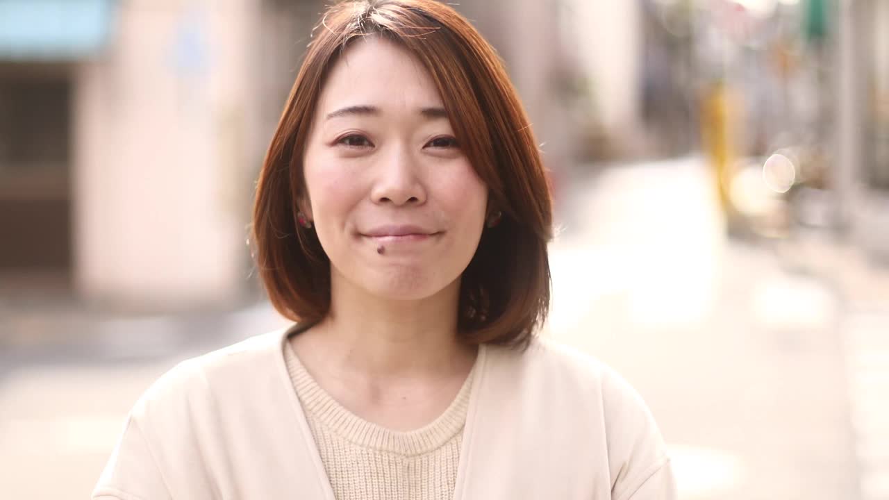 一位日本妇女在街上微笑。视频素材