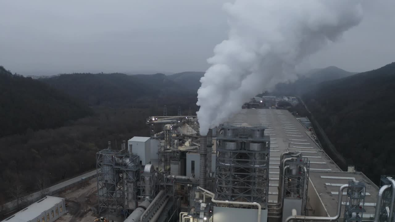 当废气从烟囱流入大气时，工业工厂的鸟瞰图视频素材