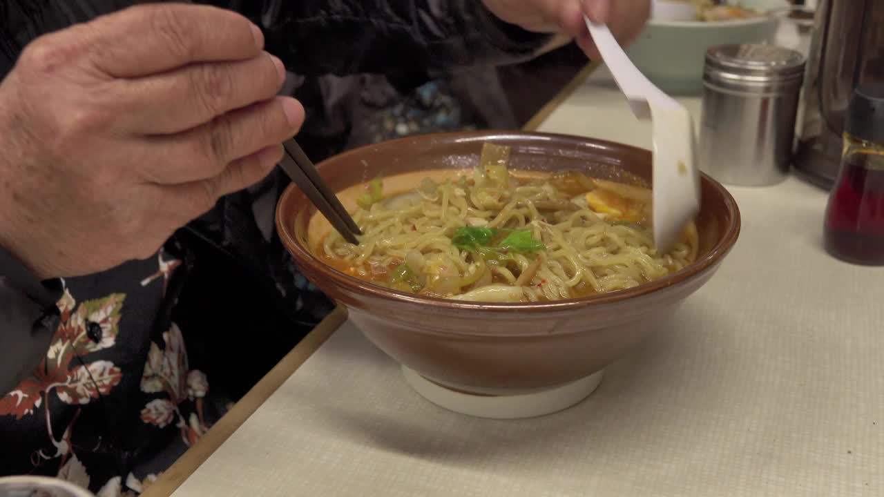 饥饿的老人吃拉面，日本面条的高汤视频下载