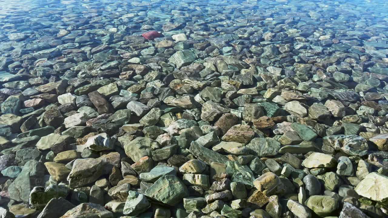 清澈的海水滚过海岸的岩石视频下载
