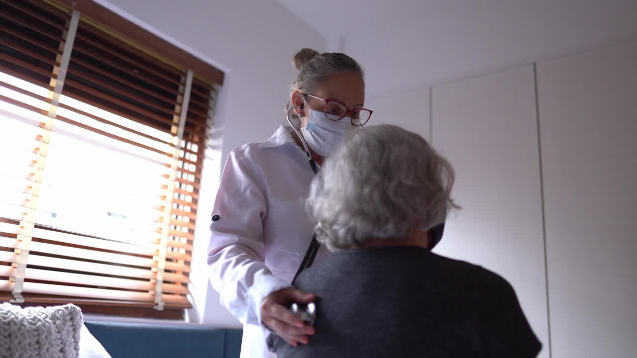 妇女戴着口罩在家接受医生检查视频素材