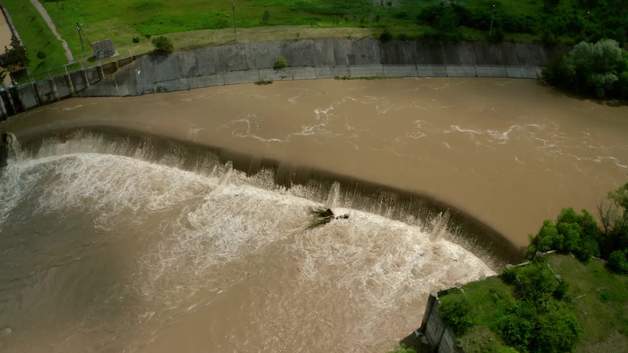 空中无人机视图。洪水和暴雨过后，河水随着充满水的堤坝向下流动。(中景)Vercion 6视频素材