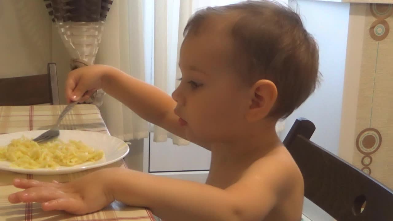 小男孩在厨房用叉子吃意大利面视频素材