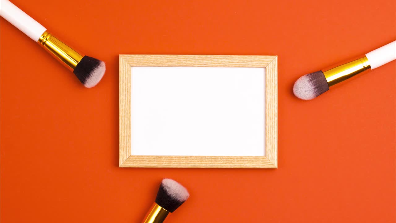 定格动画模型木制画框俯视图化妆品刷子设置为化妆在橙色的背景。化妆概念模板与复制空间平面lay视频下载