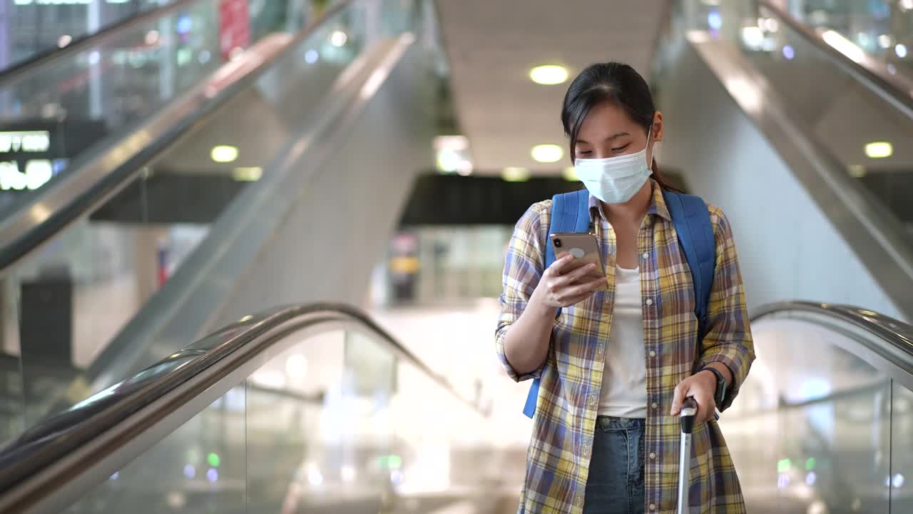 亚洲女性在机场使用智能手机视频素材