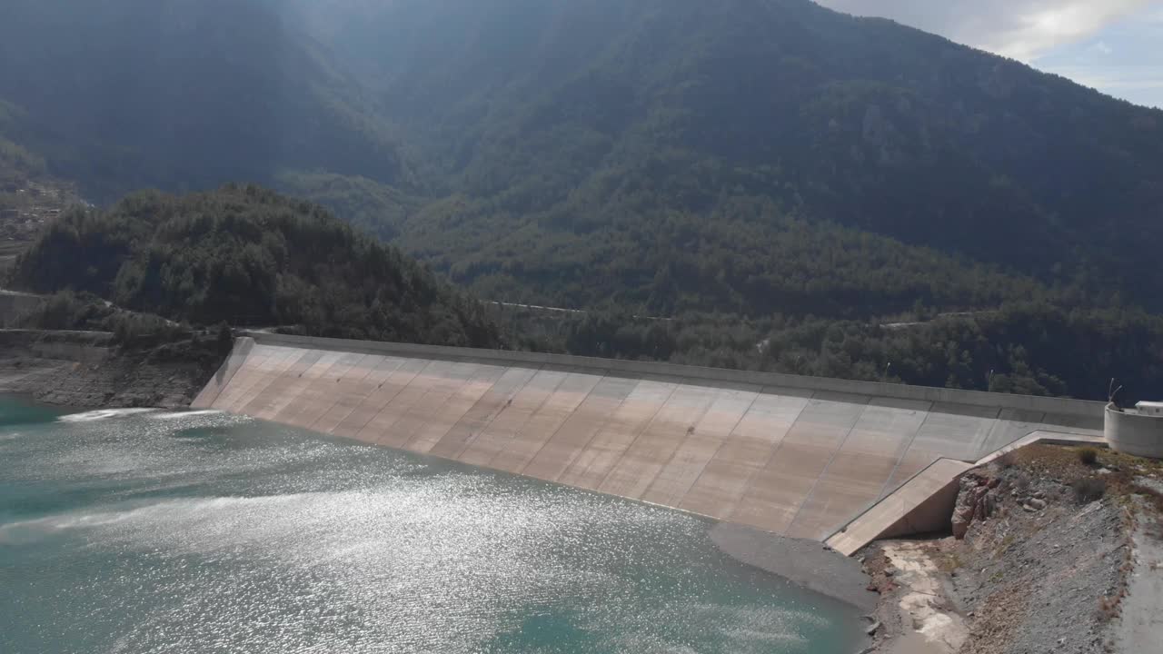 无人机拍摄的有平静碧水的水坝。山上的水库。水电站。水电站。可再生能源。可持续发展视频素材