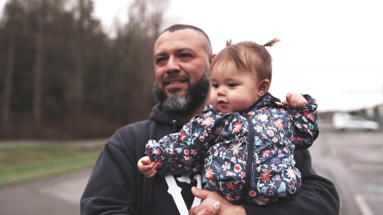西班牙爸爸带着可爱的蹒跚学步的女儿散步视频素材
