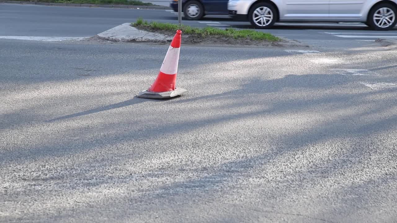 城市街道沥青路面上的交通锥警告司机由于道路施工和汽车通过的危险视频素材