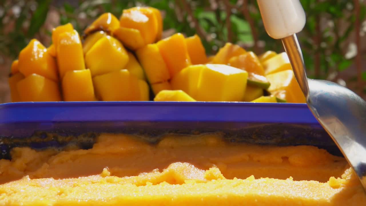 勺子正在慢慢舀起冰冻芒果冰淇淋视频下载