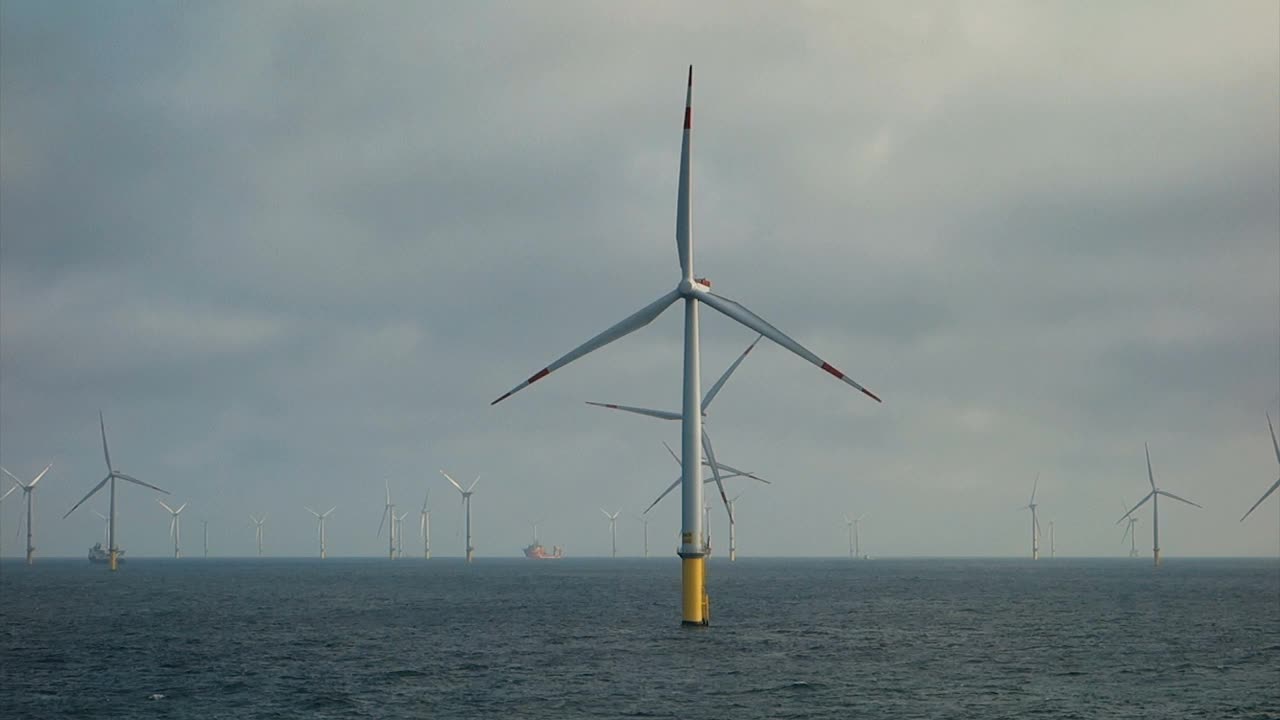 对在北海生产的大型海上风力涡轮机的看法。水轮机之间的超大型转移船(船、轮渡)。视频素材