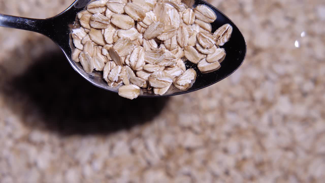 一个勺子和大燕麦片的特写，和大量的燕麦片旋转视频下载