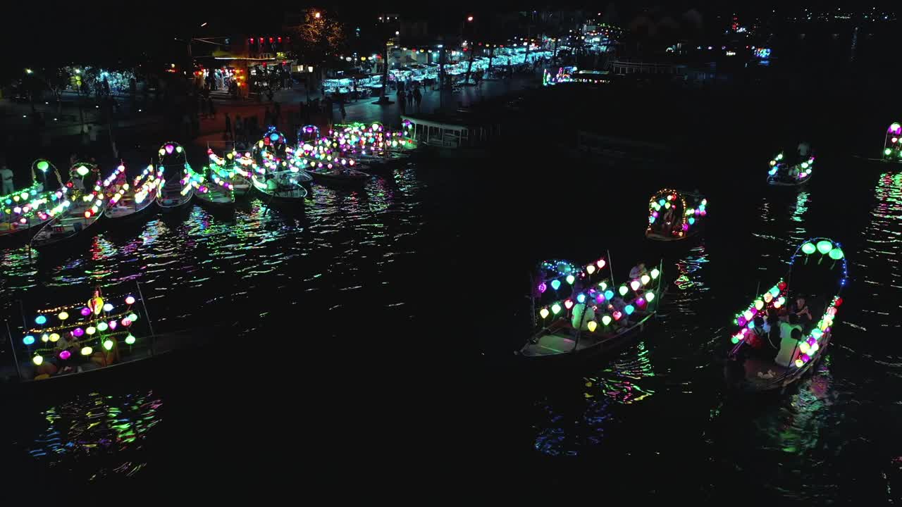 在会安的桥上，夜里的船带着灯笼往回拉视频素材