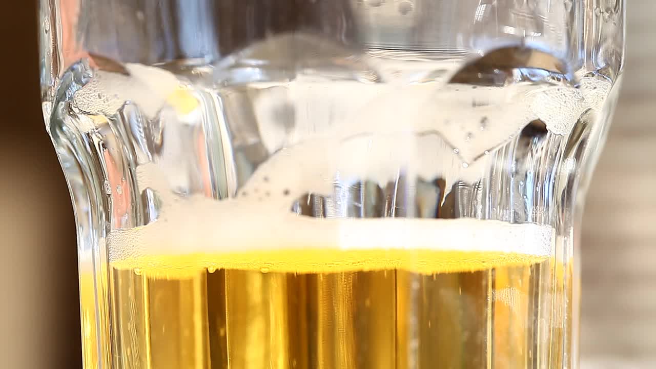 啤酒清淡，在玻璃杯中倒入白色泡沫。视频素材
