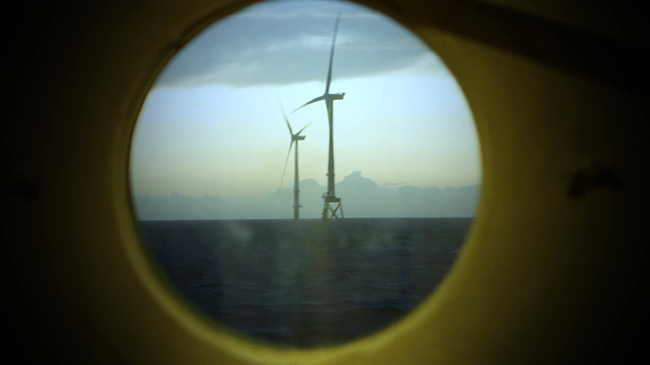 海上风力机、风电场真圆窗在日出时从帆船上俯瞰。戏剧性的天空。视频下载