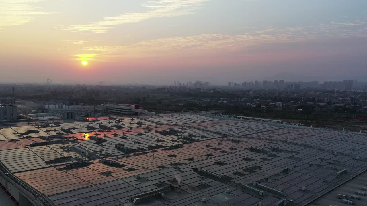 黄昏时分安装在工厂屋顶上的太阳能电池板的鸟瞰图视频下载