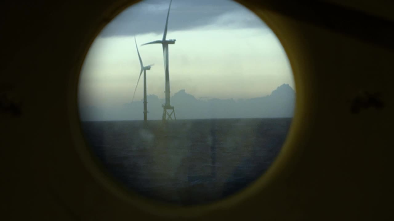 日落时分，从帆船上看海上风力发电机、风力发电场真圆窗。戏剧性的,红色的天空。视频素材