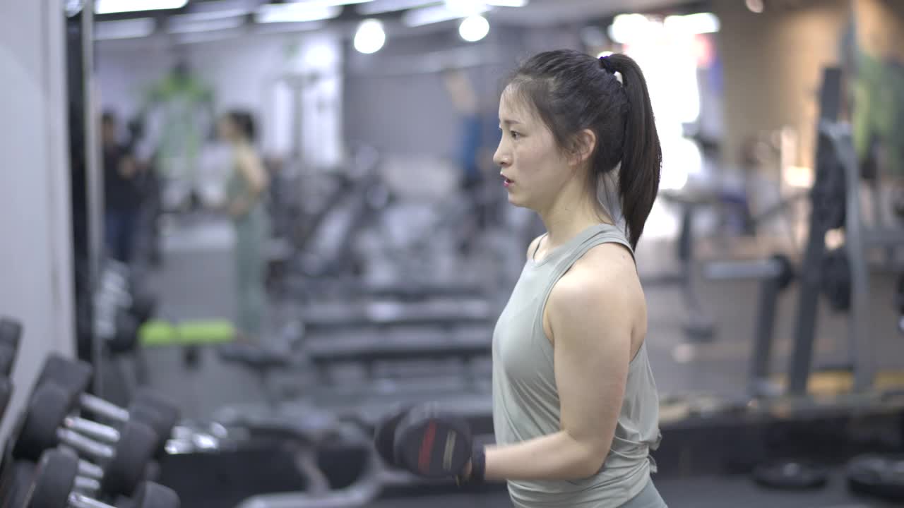 年轻的亚洲女性在健身房锻炼视频下载