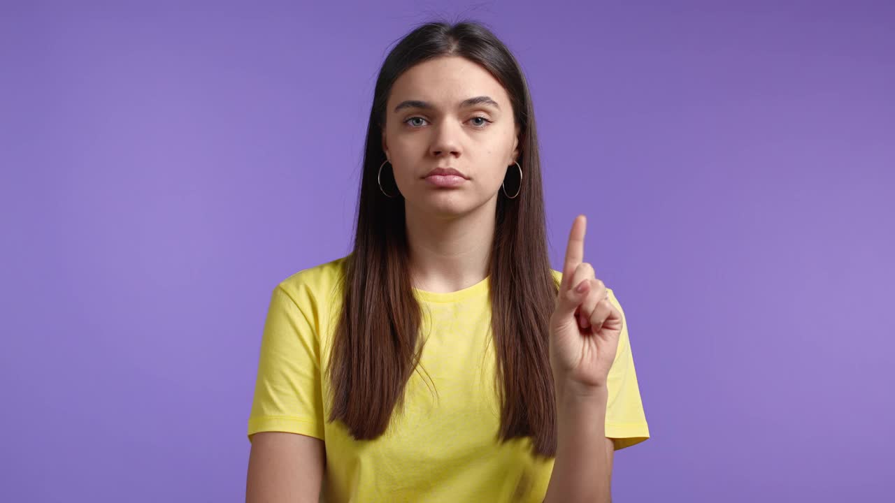 肖像严肃的女人显示拒绝手势停止手指手势。别跟我耍花招。严重女孩孤立在紫色背景上。视频素材