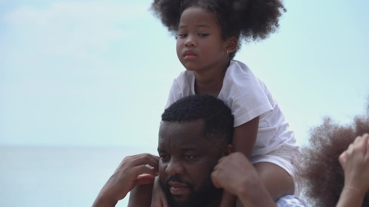 非裔美国人家庭愉快地在海滩上散步。视频素材