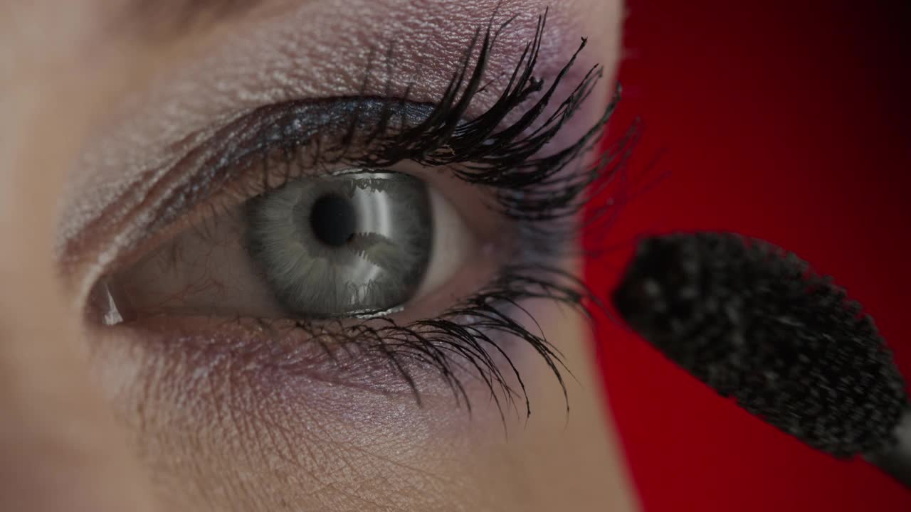 一个女孩用睫毛膏的蓝色眼睛和睫毛的特写。视频下载
