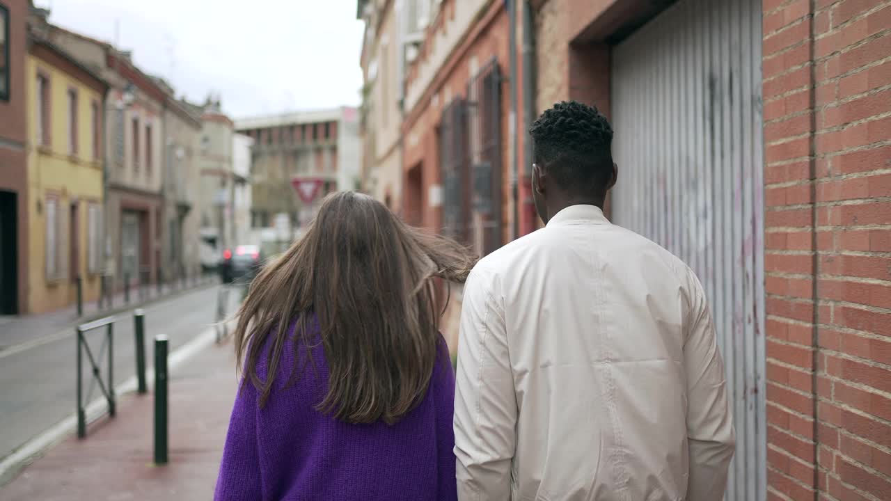 一名黑人男子和一名白人女子一起走在城市街道上，多元化的概念视频下载