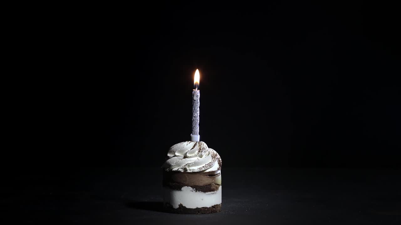 黑色背景上的蜡烛生日蛋糕视频素材