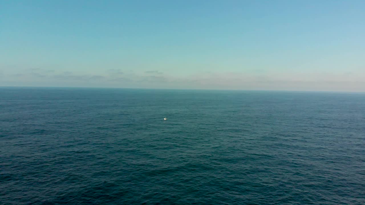 小船独自航行在北方的蓝色海洋上。船，海，海，迷失，阳光。无人机航拍。视频素材