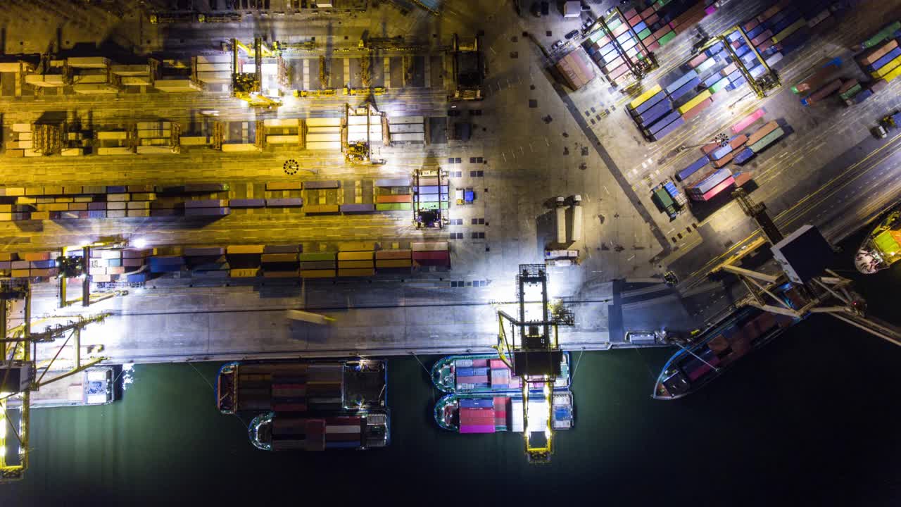 航空顶视图超或时间流逝视频，夜间集装箱和船舶在国际货运港口视频素材