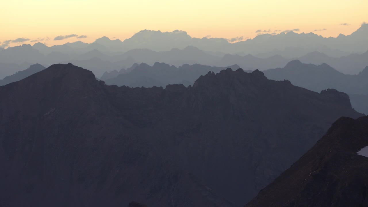 航拍显示了瑞士阿尔卑斯山脉在日出时的一系列山脉。视频素材