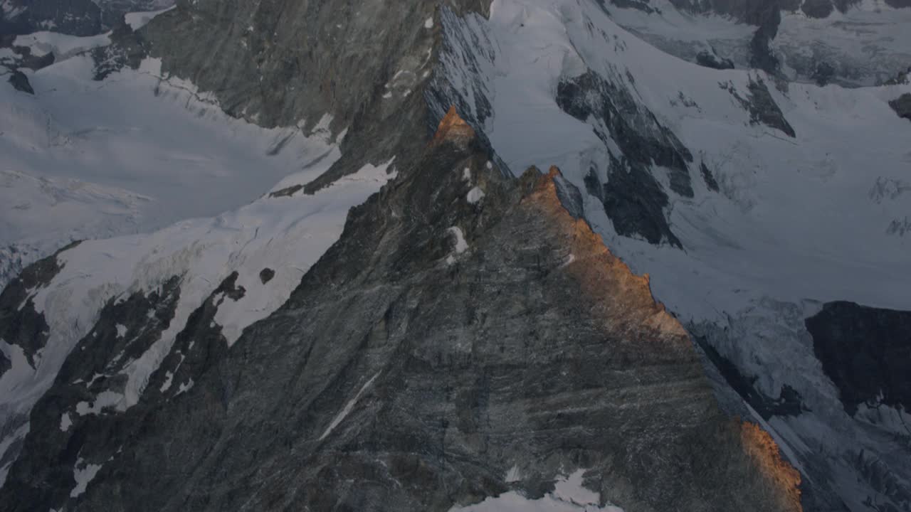 鸟瞰图在瑞士阿尔卑斯山马特洪峰附近的冰脊飞行，清晨。视频下载