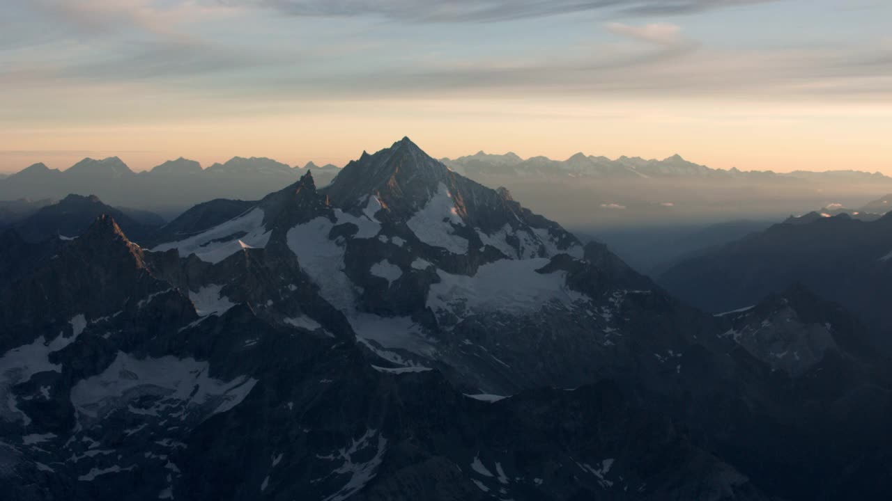 航拍盘旋在瑞士阿尔卑斯山的一座冰雪覆盖的山旁边。视频下载