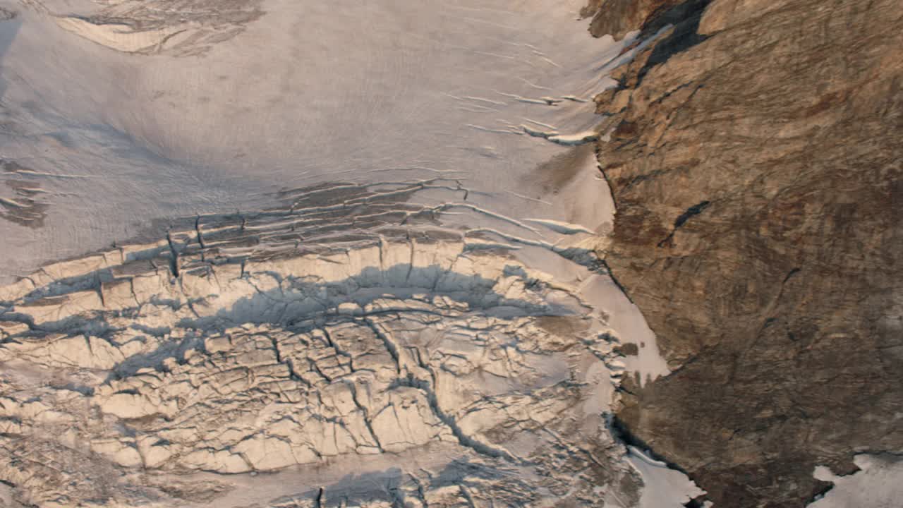 空中拍摄的瑞士阿尔卑斯山冰川的冰的一面视频下载