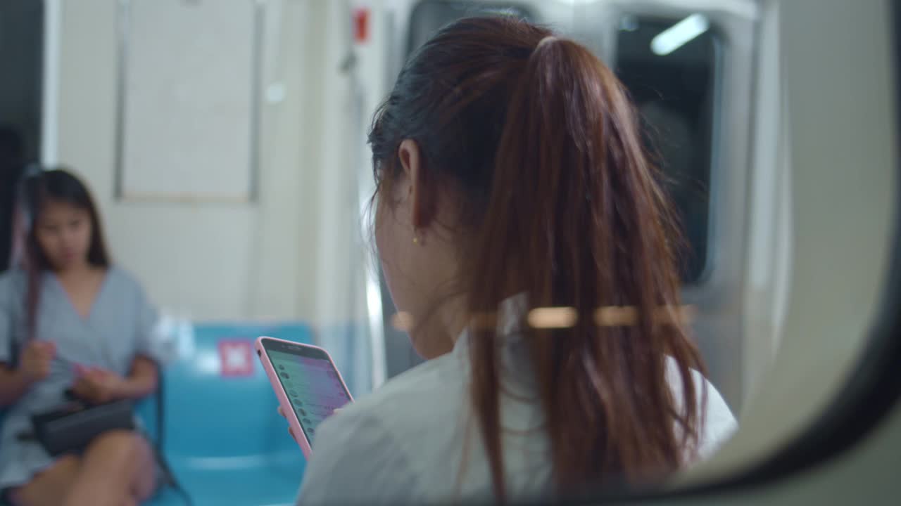 女人在乘坐地铁时使用智能手机，特写视频素材