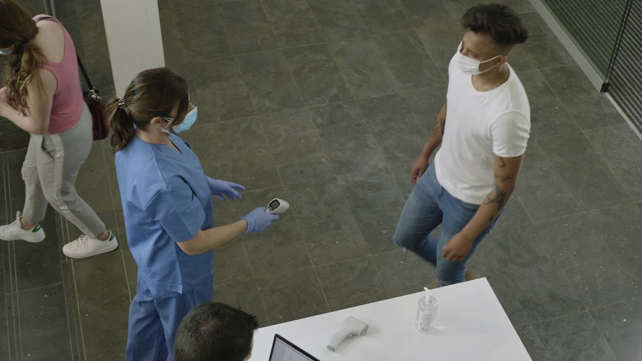 医护人员通过数字体温计检查访客的体温视频素材