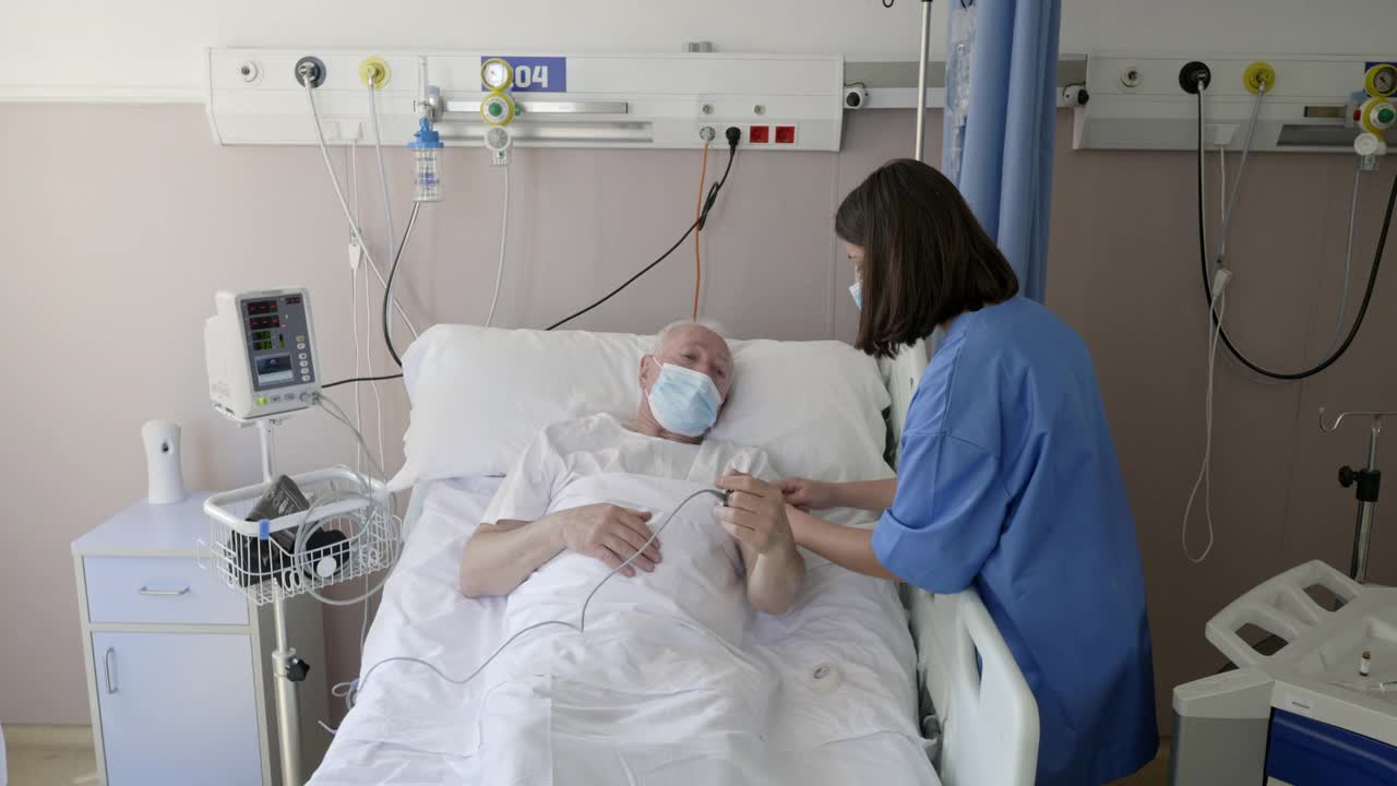 在医院病床上治疗老年病人的护士视频素材