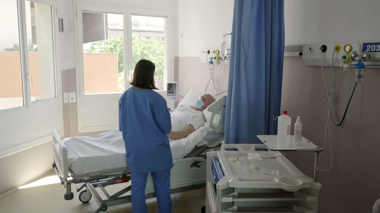 护士在大流行期间在医院治疗老人视频素材
