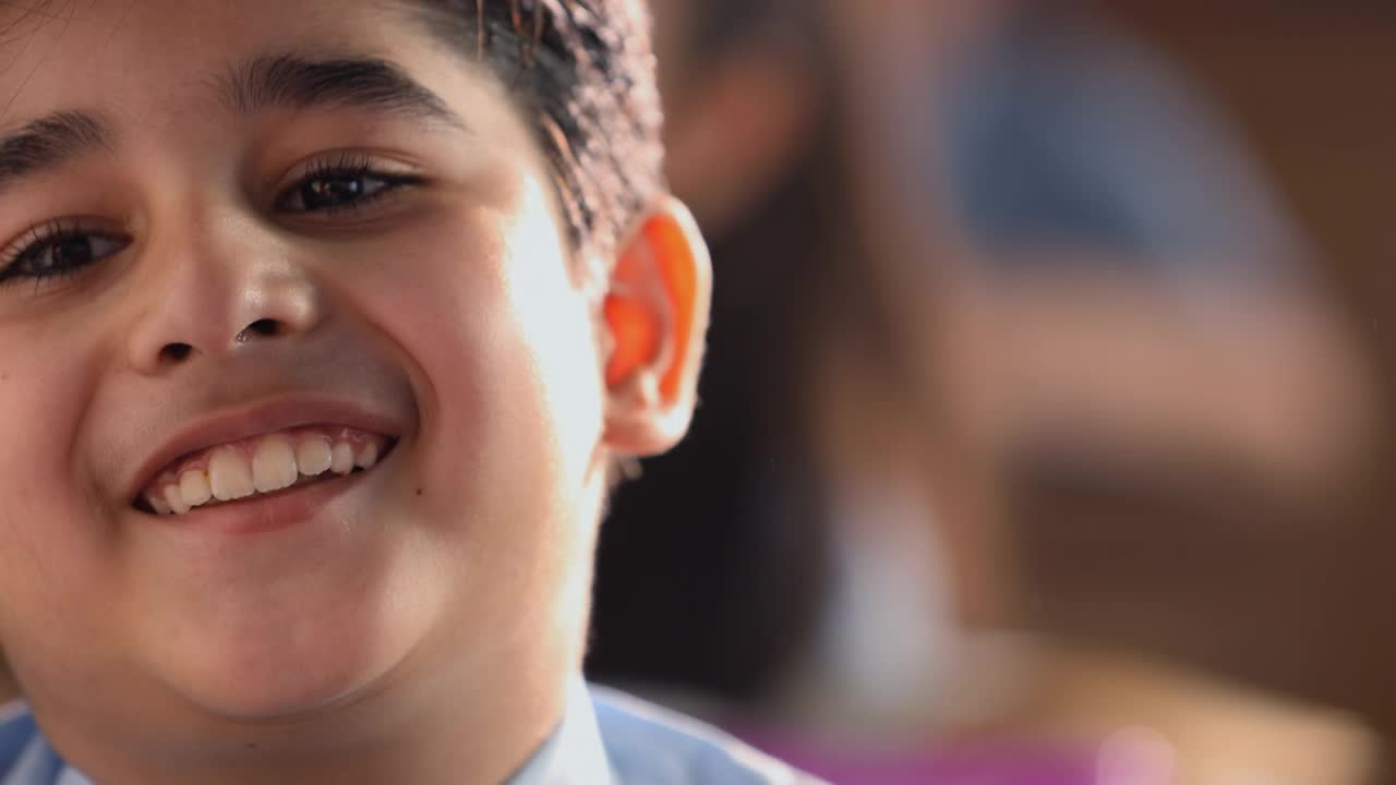 微笑的男孩在教室里聊天的特写镜头视频下载